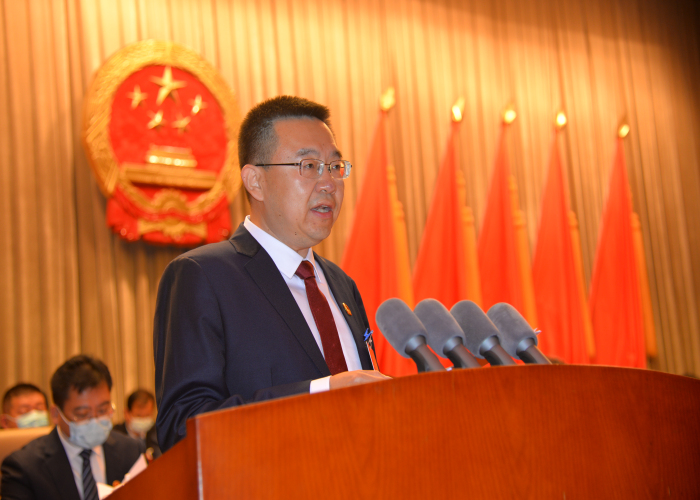 曹龙代表县政府向大会报告工作